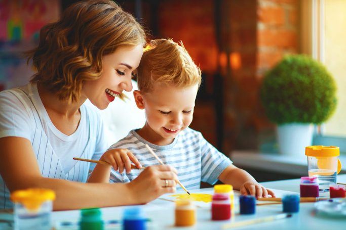 mother and child son painting draws in creativity in kindergarten